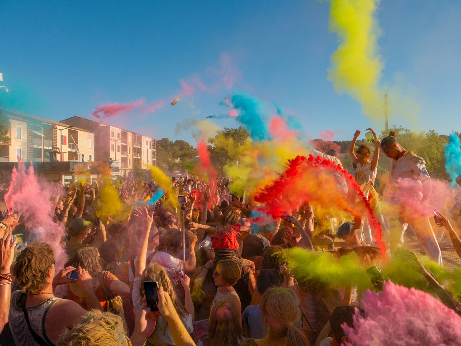 Un photo montrant une foule lors d'un festival de couleurs, envoyant de la poudre colorée dans les airs