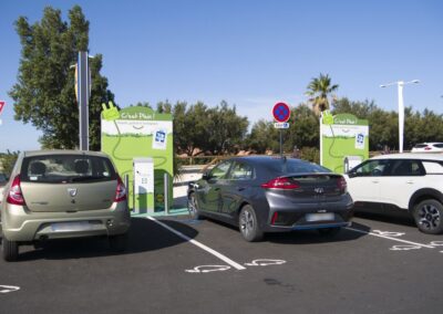 Photo de deux bornes de recharge pour voitures électriques avec trois voiture en train de se rechargées
