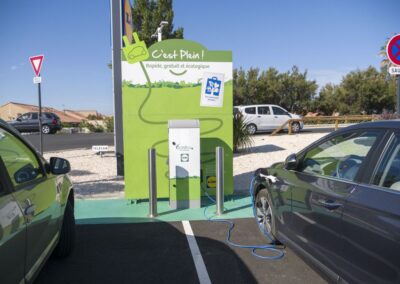 Photo d'une borne de recharge pour voitures électriques avec une voiture en train de se rechargée